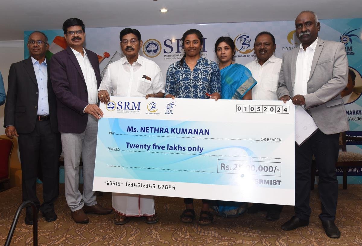 Nethra Kumanan (c), along with her parents (on her right), received a cheque for 25 lakh rupees from the SRM IST Founder and Chancellor T.R. Paarivendhar (third from left) on Wednesday.